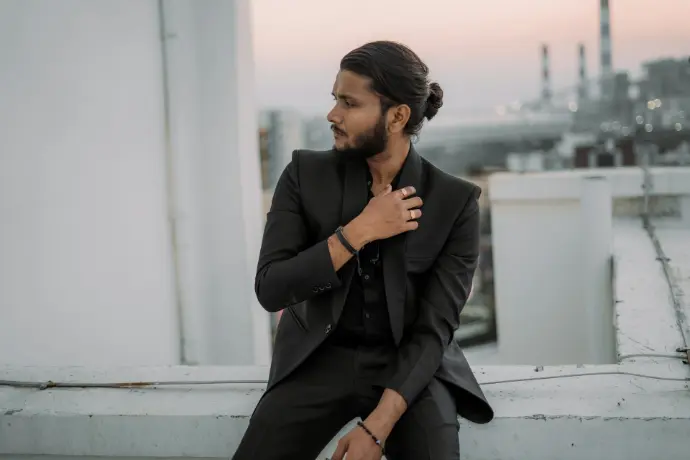 A man in a suit sitting on a ledge